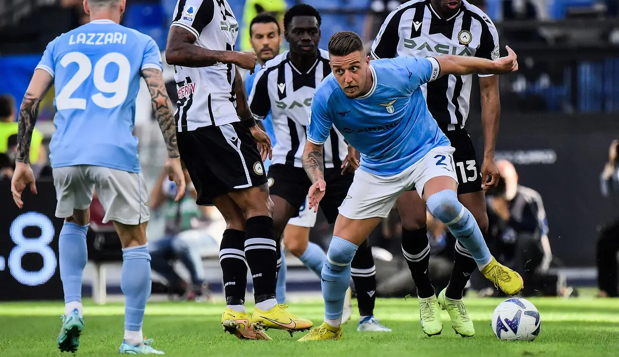Pemain Lazio, Sergej Milinkovic-Savic menggiring bola melewati pemain Udinese pada laga lanjutan Liga Italia 2022/2023 di Olympic Stadium, Roma, 16 Oktober 2022. Milinkovic-Savic merupakan salah satu pilar penting di skuad Lazio. Ia tercatat telah memainkan 341 pertandingan di semua kompetisi bersama Biancoceleste sejak tahun 2015. Sejauh ini, pria berkebangsaan Serbia tersebut telah mengemas 69 gol dan 59 assist. Lazio dikabarkan berencana menjual sang pemain pada bursa musim panas ini. (AFP/Filippo Monteforte)
