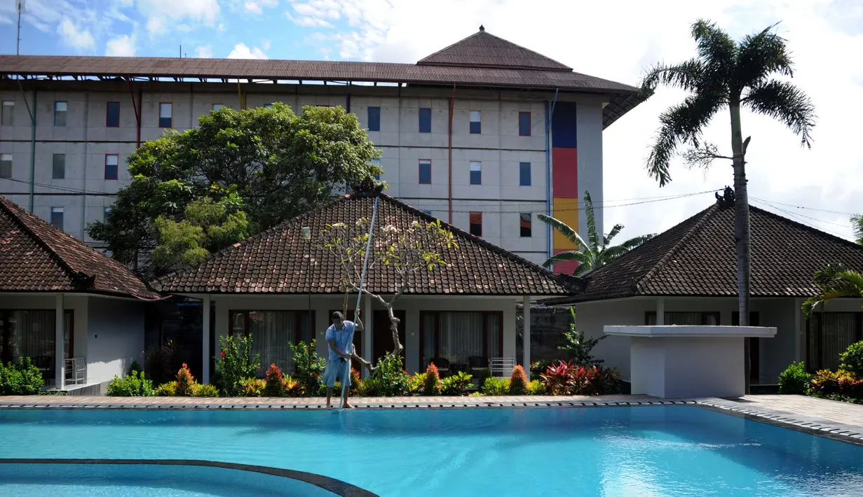 <p>Seorang pekerja membersihkan kolam renang sebuah hotel saat Pemberlakuan Pembatasan Kegiatan Masyarakat (PPKM) Level 3 di Kuta, Badung, Bali, Jumat (23/7/2021). PPKM Level 3 di Bali berlaku hingga 25 Juli mendatang. (SONNY TUMBELAKA/AFP)</p>