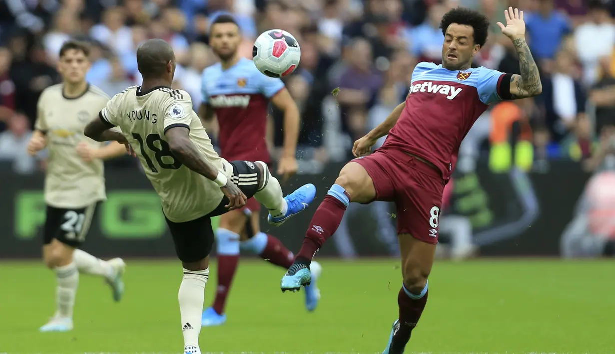 Bek Manchester United, Ashley Young (kiri) berebut bola dengan gelandang West Ham, Felipe Anderson selama pertandingan lanjutan Liga Inggris di stadion London (22/9/2019). West Ham menang 2-0 atas Manchester United. (AP Photo/Leila Coker)