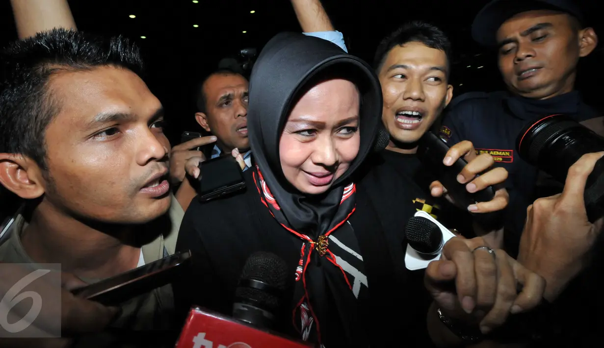 Istri Pelaksana Tugas (Plt) Gubernur Sumatera Utara Tengku Erry Nuradi, Evi Diana, menghindar dari wartawan usai diperiksa KPK, Jakarta, Kamis (5/11/15). Evi yang diperiksa sebagai saksi untuk Gatot Pujo Nugroho. (Liputan6.com/Helmi Afandi) 