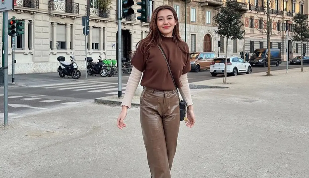 Aaliyah Massaid tampil serba Coklat dari atasan lengan pendek dipadukan inner lengan panjang, celana kulit, dan sneakers putihnya. [@aaliyah.massaid]
