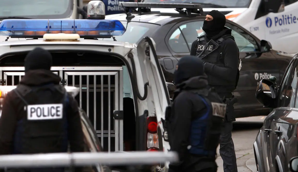 Polisi khusus Belgia dalam sebuah razia, untuk mencari fundamentalis Muslim yang terkait dengan serangan mematikan di Paris, di pinggiran kota Brussels, Molenbeek, Senin (16/11). (REUTERS/Yves Herman)
