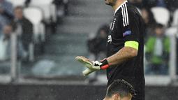 Gaya kiper Juventus, Gianluigi Buffon saat mampu menahan sepakan pemain Real Madrid, Cristiano Ronaldo pada leg pertama Liga Champions di Allianz Stadium, Turin, (3/4/2018). Ronaldo mencetak dua gol ke gawang Juventus. (AFP/Alberto Pizzoli)