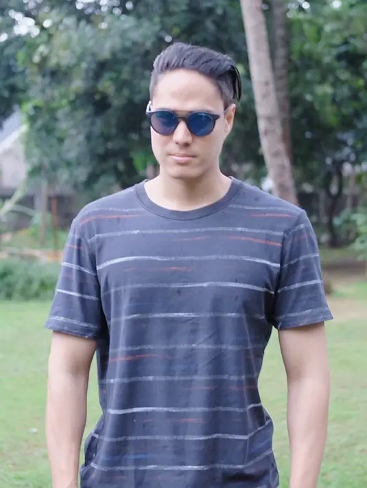 Tak melulu dengan kacamata hitam, saudara kembar Marcel Chandrawinata ini juga modis dengan kacamata biru. Gayanya itu disesuaikan dengan warna kaus stripe yang dipakainya. (Liputan6.com/IG/@mischach)