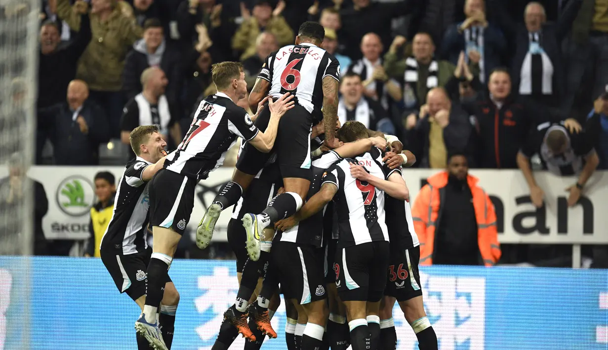 Striker Newcastle United, Callum Wilson dikerumuni oleh rekan setimnya setelah mencetak gol ke gawang Arsenal selama pertandingan Liga Inggris di St James' Park di Newcastle-upon-Tyne, Inggris (17/5/2022). Newcastle United menang atas Arsenal 2-0. (AFP/Oli Scarff)