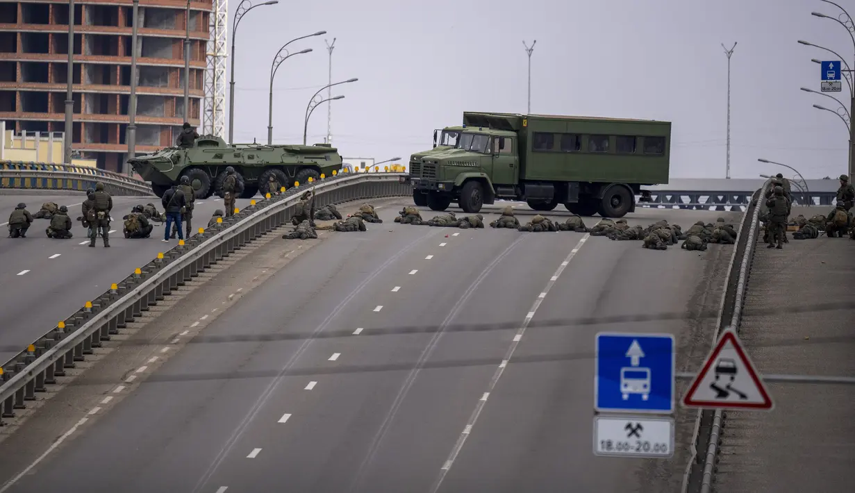 Tentara Ukraina mengambil posisi di sebuah jembatan di dalam Kota Kiev, Ukraina, Jumat (25/2/2022). Rusia menekan invasinya sampai ke pinggiran Kiev setelah melepaskan serangan udara di kota-kota dan pangkalan militer serta mengirimkan pasukan dan tank dari tiga sisi. (AP Photo/Emilio Morenatti)