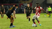 Aksi winger Persis Solo, Moussa Sidibe saat mencoba melewati pemain Madura United pada lanjutan BRI Liga 1 2023/2024 di Stadion Manahan Solo, Selasa (30/1/2024) malam WIB. (Bola.com/Radifa Arsa)