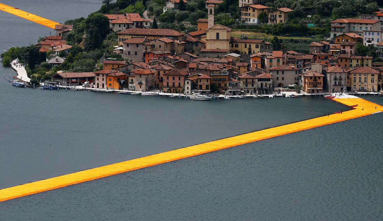 Instalasi seni 'The Floating Piers' buatan seniman  Christo Vladimirov Yavachev atau dikenal sebagai Christo , di Danau Iseo , Italia utara , (16/6).Pria 80 tahun ini  merancang karya seni besarnya untuk menarik wisatawan.  (REUTERS / Stefano Rellandini)