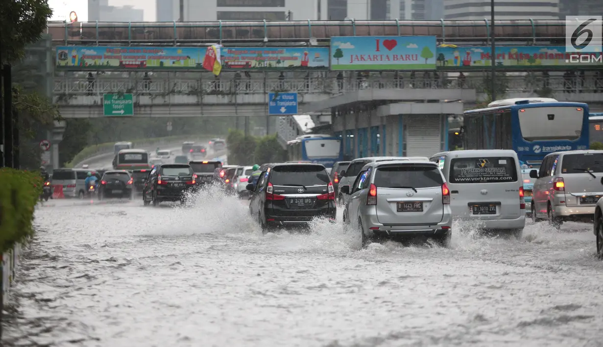 Sejumlah kendaraan melintas menerjang genangan air di kawasan Bunderan HI, Jakarta, Kamis (22/11). Genangan air hujan setinggi 40 cm tersebut disebabkan hujan deras yang melanda Jakarta pada siang hari. (Liputan6.com/Faizal Fanani)