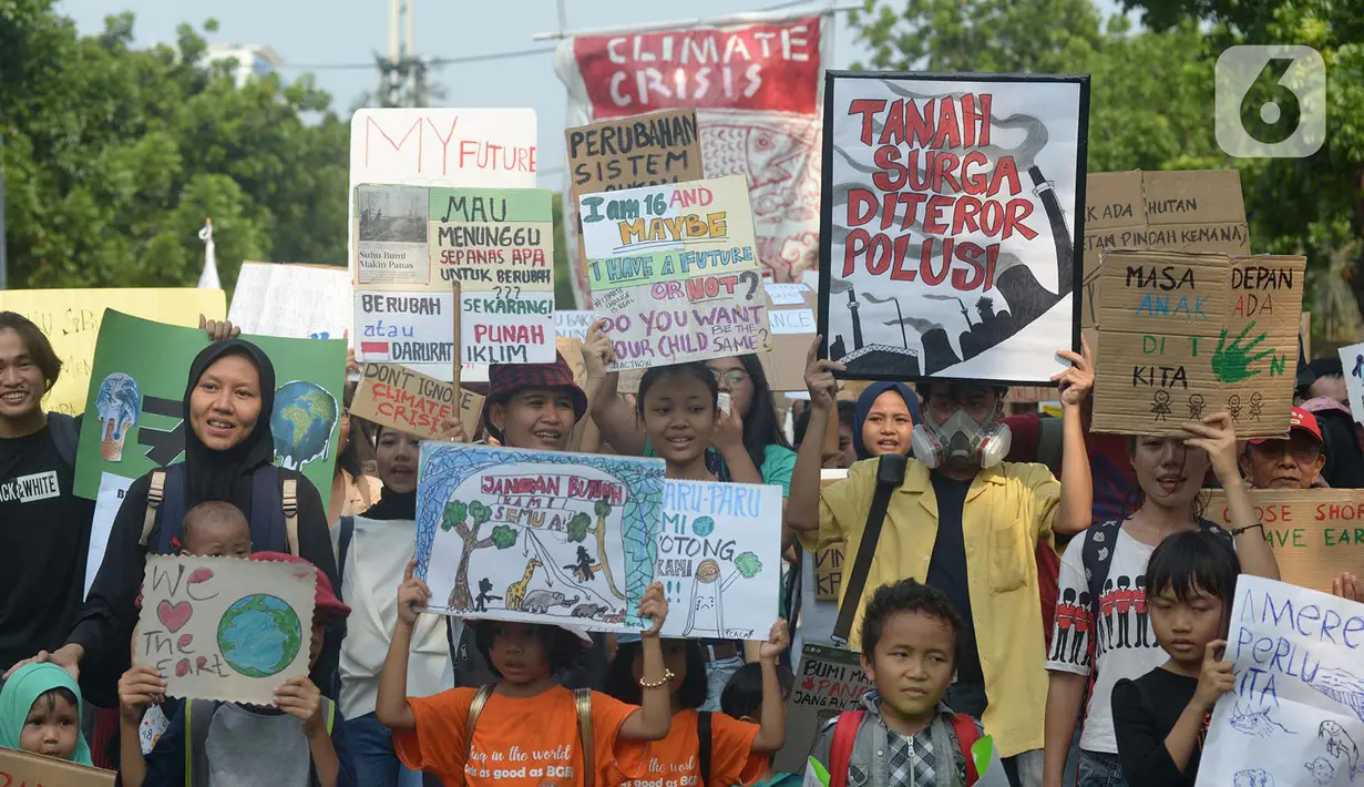 Aktivis lingkungan hidup dari berbagai LSM membawa spanduk bertuliskan pesan saat berjalan kaki menuju Taman Aspirasi di Istana Merdeka, Jakarta, Jumat (29/11/2019). Aktivis meminta pemerintah segera mendeklarasikan perubahan iklim yang semakin kritis. (merdeka.com/Imam Buhori)