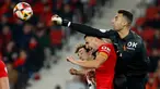 Kiper Mallorca Dominik Greif (kanan) berebut bola dengan pemain depan Real Sociedad Ander Barrenetxea (kiri) saat pertandingan sepak bola leg pertama semifinal Copa del Rey (Piala Raja) di Stadion Mallorca Son Moix, Palma de Mallorca, 6 Februari 2024. (JAIME REINA/AFP)