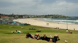 Sebelumnya, dua pelaku bersenjata, yang diyakini merupakan ayah dan anak, melepaskan tembakan saat ribuan warga Yahudi merayakan Hanukkah. Tampak dalam foto, orang-orang terlihat di Pantai Bondi, Sydney, Australia pada Senin 15 Desember 2025. (Saeed KHAN/AFP)