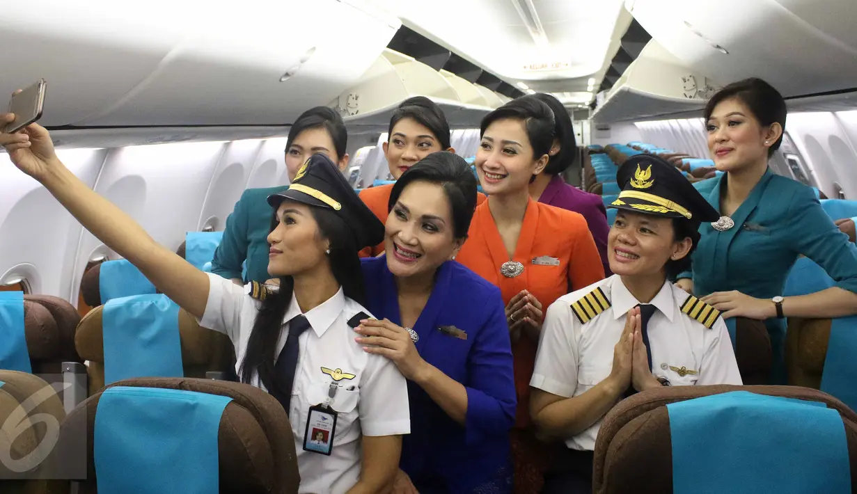 Kapten pilot Garuda Indonesia Ida Fiqria dan kopilot Sari Ardisa berpose dengan para pramugari di bandara Minangkabau, Padang, Sumbar, Jumat (21/4). (Liputan6.com/Angga Yunair)