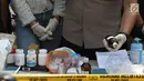 Petugas menunjukkan barang bukti bahan pembuat narkoba saat rilis di sebuah perumahan di Pondok Rajeg, Cibinong, Senin (24/9). Polisi menyita sejumlah barang bukti diantaranya 158 gram sabu, 3000 pil ekstasi. (Liputan6.com/Helmi Fithriansyah)