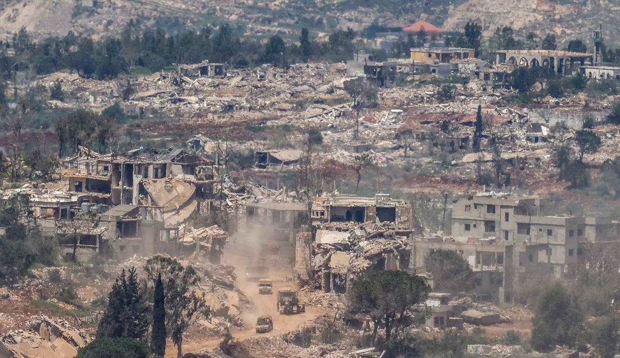 Foto menunjukkan kendaraan militer Israel melaju di antara rumah-rumah yang hancur di Lebanon Selatan dekat perbatasan dengan Israel, pada Senin 27 April 2026. (Jalaa MAREY/AFP)