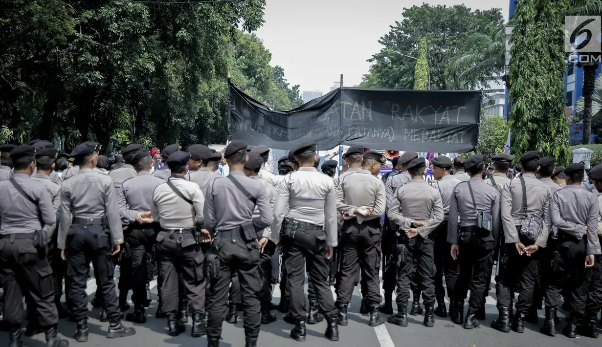 Petugas kepolisian berjaga saat massa aksi yang tergabung dalam Aliansi Badan Eksektutif Mahasiswa Seluruh Indonesia (BEM SI) menggelar aksi longmarch menuju Istana Merdeka, Jakarta, Senin (22/5). (Liputan6.com/Faizal Fanani)