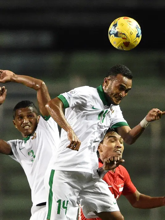 Duel udara terjadi saat Indonesia versus Singapura di Piala AFF 2016, Manila, Jumat (25/11). Sempat tertinggal di babak pertama, Indonesia mampu membalikkan keadaan di babak kedua. (AFP PHOTO / Ted Aljibe)