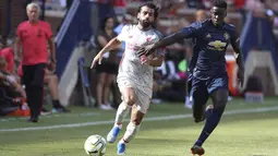 Penyerang Liverpool, Mohamed Salah, berebut bola dengan pemain Manchester United, Axel Tuanzebe, pada laga ICC 2018 di Stadion Ann Arbor, Michigan, Minggu (29/7/2018). Liverpool menang 4-1 atas Manchester United. (AP/Carlos Osorio)