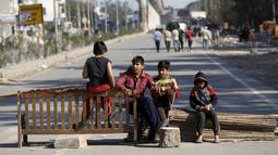Anak-anak duduk di blokade jalan dalam demonstrasi oleh anggota kasta Jat di negara bagian Haryana ke New Delhi, India,Minggu (21/2). Demonstrasi dan aksi kekerasan akibat kelangkaan air di wilayah tersebut menewaskan 10 orang. (REUTERS/Adnan Abidi)