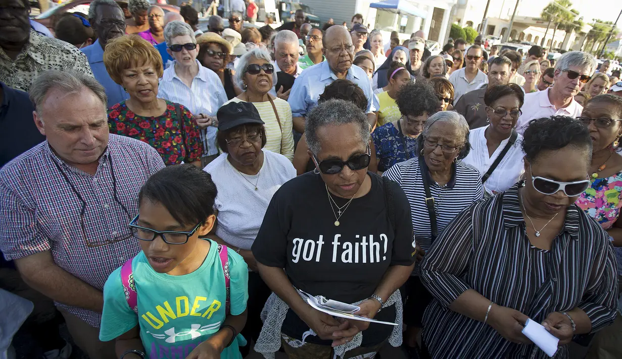 Sejumlah jemaat berkumpul untuk berdoa di luar Gereja Emanuel, Charleston, Amerika Serikat, Minggu (21/6/2015). Gereja tersebut dibuka kembali untuk ratusan jemaat yang berkabung usai penembakan yang menewaskan 9 orang. (REUTERS/Carlo Allegri) 