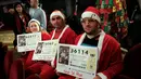 Sejumlah peserta mengenakan kostum Sinterklas selama mengikuti Lotre Natal El Gordo di Spanyol, Selasa (22/12). Lotre ini dilaksanakan pada tanggal 22 Desember setiap tahun dan Peserta diharapkan membeli tiket dengan 5 digit nomor.(REUTERS/Andrea Comas)