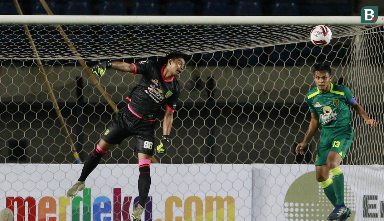 Kiper Persebaya Surabaya, Satria Tama (kiri) dan bek Rachmat Irianto berusaha menghalau bola saat menghadapi Persik Kediri dalam laga Grup C Piala Menpora 2021 di Stadion Si Jalak Harupat, Bandung, Selasa (23/3/2021). (Bola.com/M Iqbal Ichsan)