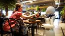 Robot humanoid mengantarkan minuman kepada pelanggan di Dawn Cafe, Tokyo, Jepang, 17 Agustus 2021. Peluncuran kafe ini bersamaan dengan Paralimpiade yang akan dibuka pada 24 Agustus. (Behrouz MEHRI/AFP)