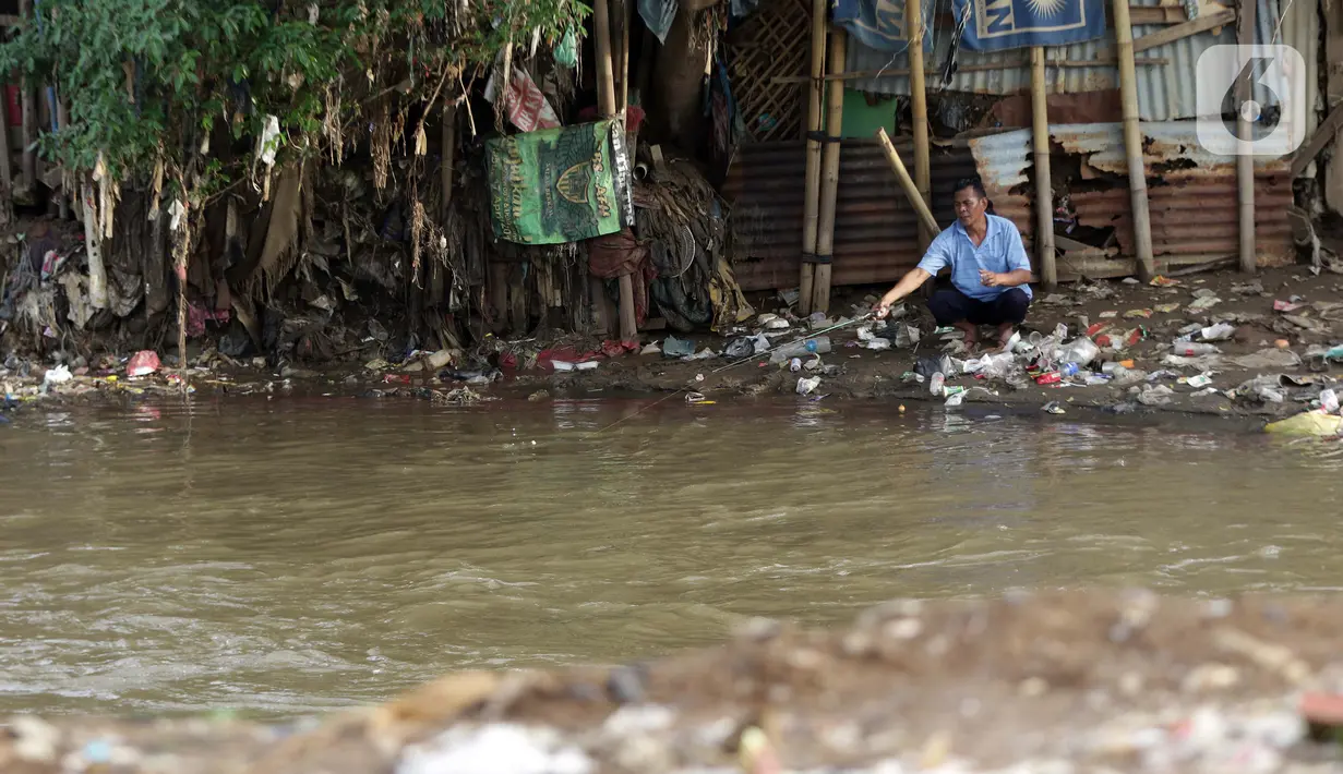Warga memancing di aliran Kali Ciliwung, Jakarta, Rabu (10/3/2021). Wagub DKI Jakarta Ahmad Riza Patria mengatakan, pembebasan lahan untuk normalisasi Kali Ciliwung sepanjang 10 KM dari sisi kiri dan kanan membutuhkan anggaran sebesar Rp 5 triliun. (Liputan6.com/Helmi Fithriansyah)