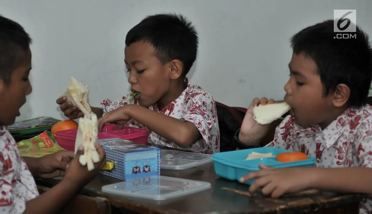 Siswa menyantap makanan tambahan saat program PMTAS di SD Negeri 01 Tanjung Priok, Jakarta, Kamis (28/3). Setiap anak mendapatkan makanan tambahan senilai Rp 10.800 setiap hari (pagi atau siang) dengan varian menu seperti buah-buahan, roti dan susu UHT. (merdeka.com/Iqbal S. Nugroho)