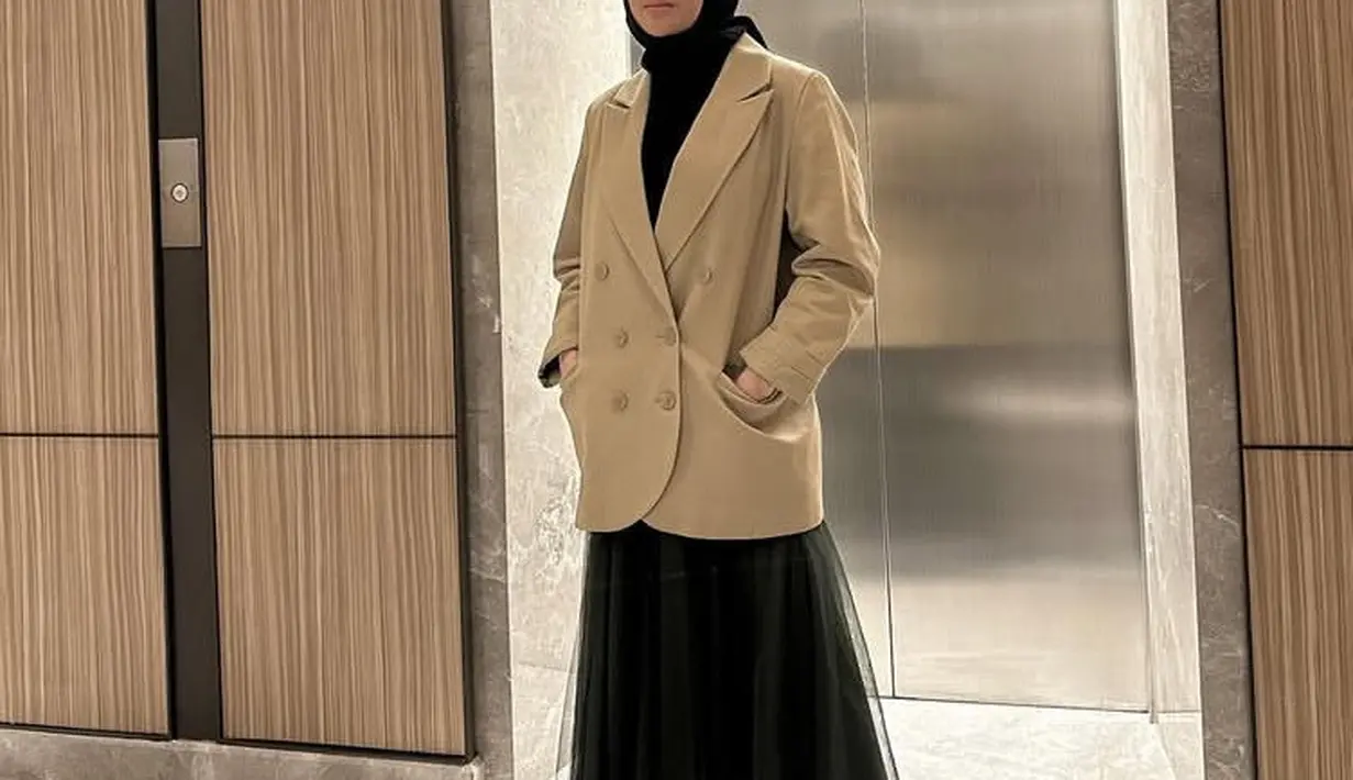 Kerudung hitam Clara Shinta dipadukan blazer oversize coklat serta rok hitam tulle. Ia juga mengenakan sepatu oxford hitam. [@clarashintareal]