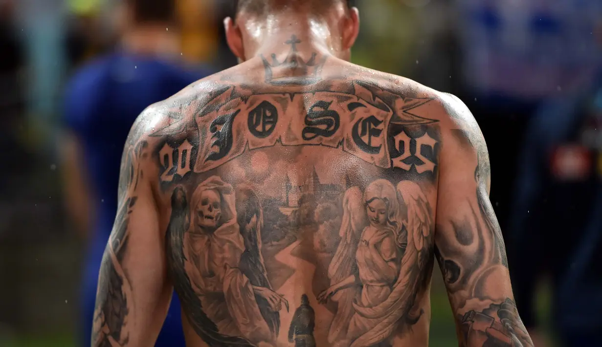 Pemain Yunani, Chose Cholevas memiliki tato unik saat berjalan keluar arena pada partai persahabatan melawan Australia di Sidney. (AFP/Saeed Khan)