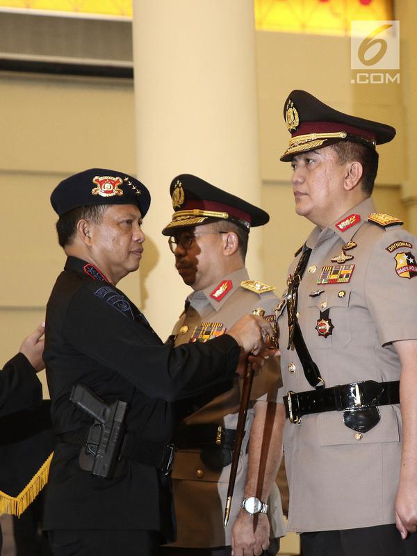 Kapolri Jenderal Tito Karnavian menyematkan lencana jabatan pada Brigjen Muhammad Iqbal selama upacara sertijab di Mako Brimob, Kelapa Dua, Depok, Rabu (14/ 11). Iqbal menjabat Kadiv Humas menggantikan Irjen Setyo Wasisto. (Liputan6.com/Herman Zakharia)