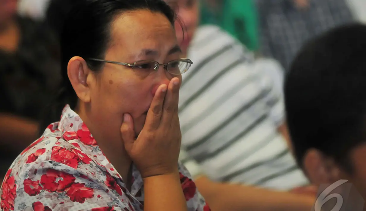 Seorang wanita tampak cemas menunggu kabar terbaru hilangnya pesawat AirAsia QZ8501 di posko Crisis Centre Terminal II Bandara Juanda, Surabaya, Jawa Timur, Senin (29/12). (Liputan6.com/Johan Tallo)
