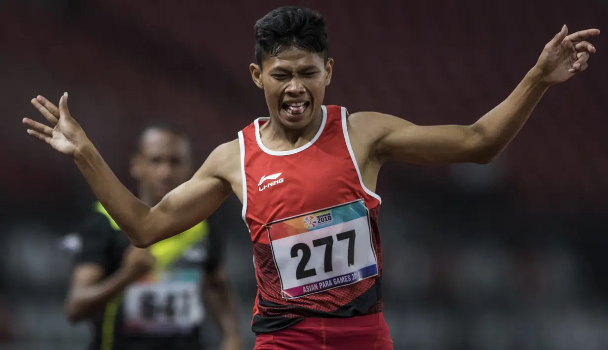 Pelari Indonesia, Sapto Yogo Purnomo, melakukan selebrasi usai meraih medali emas cabang atletik nomor lari 200 meter T 37 Asian Para Games di SUGBK, Jakarta, Senin (8/10/2018). (Bola.com/Vitalis Yogi Trisna)