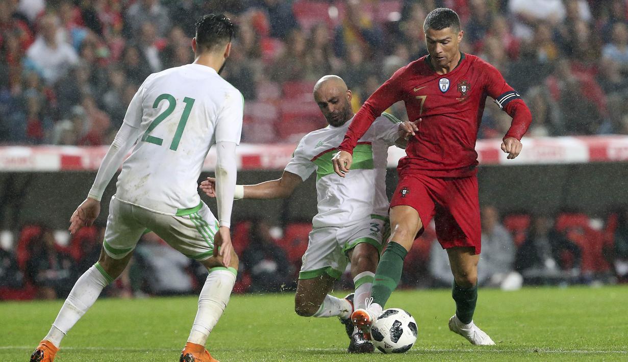 Striker Portugal, Cristiano Ronaldo, berusaha melewati pemain Aljazair pada laga uji coba di Estadio da Luz, Jumat (8/6/2018). Portugal menang 3-0 atas Aljazair. (AP/Armando Franca)