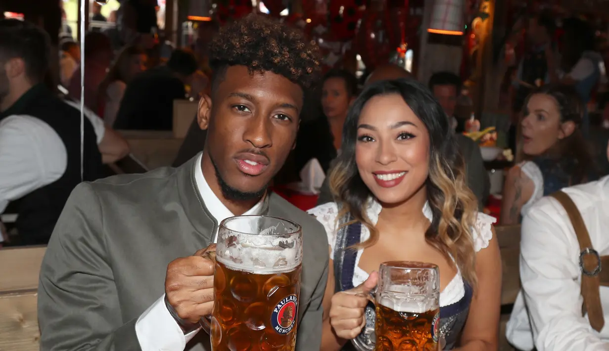 Penyerang Bayern Munchen, Kingsley Coman bersama kekasihnya Sephora Goignan menikmati bir saat menghadiri festival bir Oktoberfest 2019 di Munich, Jerman selatan (6/10/2019). (AFP Photo/Stefan Matzke)