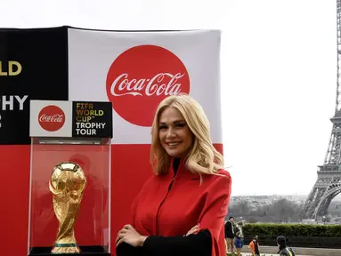 Duta Besar FIFA World Cup 2018, Victoria Lopyreva berpose dengan trofi Piala Dunia dengan latar menara Eiffel selama FIFA World Cup Trophy Tour di Paris (20/3). Piala Dunia 2018 diselenggarakan 14 Juni dan 15 Juli 2018 di Rusia. (AFP Photo/Franck Fife)