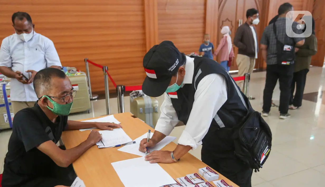 Petugas PPIH mengisi dokumen di asrama haji Pondok Gede, Jakarta, Selasa (31/5/2022). Petugas  PPIH (Petugas Panitia Penyelenggara Ibadah Haji) sebanyak di  828 orang di berangkatkan pada Rabu (1/6/2022) yang di bagi daerah kerja ke Jeddah, Madinah dan Mekkah. (Liputan6.com/Herman Zakharia)