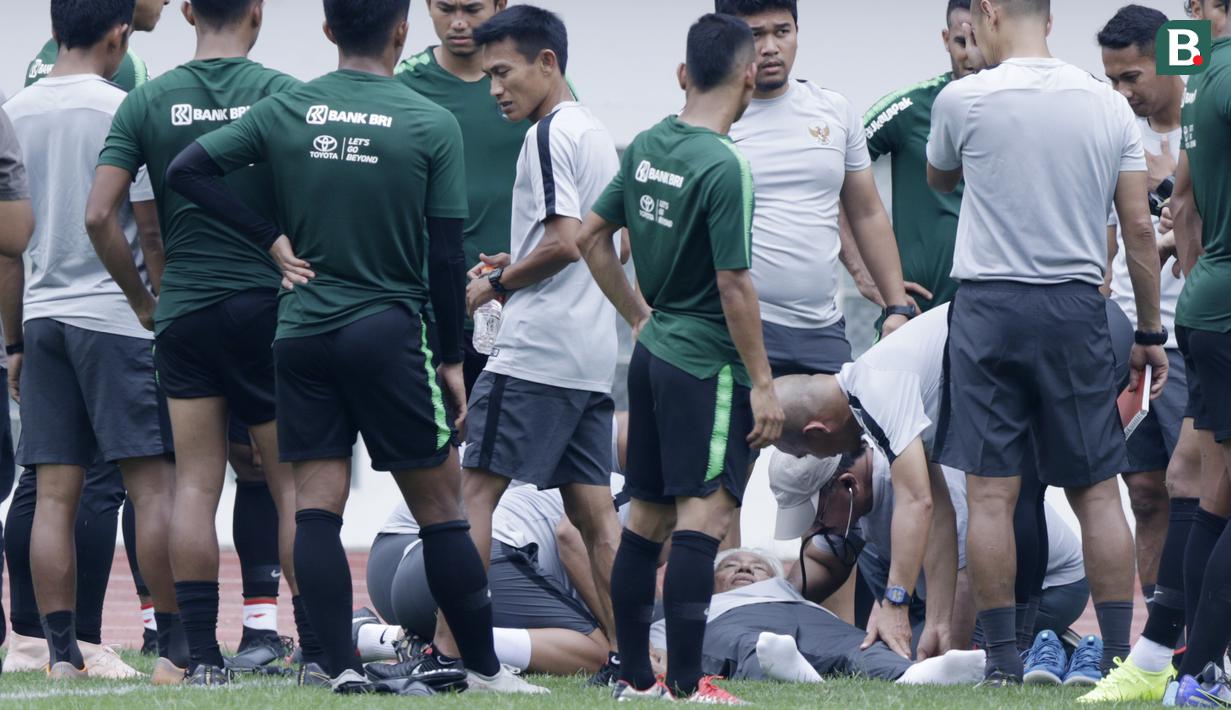 Dokter Timnas Indonesia, Syarif Alwi, memeriksa Danurwindo, yang pingsan usai memantau latihan di Stadion Wibawa Mukti, Jawa Barat, Sabtu (03/11/2018). Danurwindo ambruk ketika tim dan ofisial melakukan sesi foto bersama. (Bola.com/M Iqbal Ichsan)