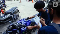 Petugas memeriksa sepeda motor sebelum dikirim menggunakan kereta di Stasiun Kampung Bandan, Jakarta Utara, Selasa (26/4/2022). PT Kereta Api Indonesia (KAI) Logistik (Kalog) menyediakan 9.280 kuota pengiriman sepeda motor gratis selama arus mudik dan arus balik Lebaran 2022. (Liputan6.com/Herman Zakharia)
