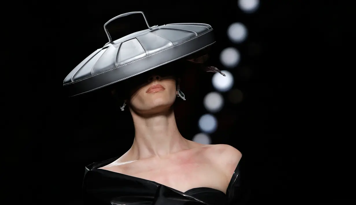 Model mengenakan busana rancangan Moschino dengan hiasan kepala berbentuk tutup tong sampah dalam Milan Fashion Week Autumn/Winter 2017 di Milan, Italia, (23/2). (AFP Photo / Marco Bertorello)