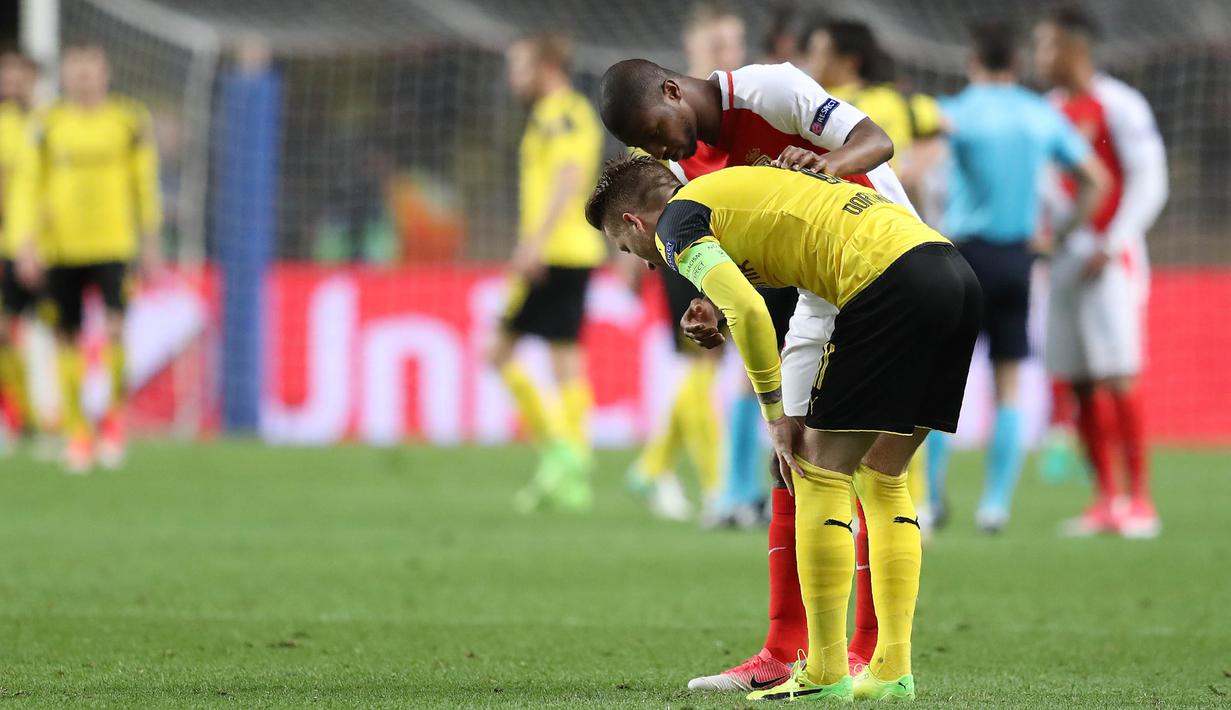 Bek AS Monaco, Almamy Toure, berusaha menenangkan striker Borussia Dortmund, Marco Reus usai laga berakhir. Lawan AS Monaco akan ditentukan lewat proses pengundian yang akan dilakukan pada Jumat (21/4/2017). (AFP/Valery Hache)