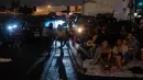 Orang-orang menonton film di luar ruangan saat pemutaran film drive-in di Union Market, Washington, 3 Agustus 2018. Walaupun antusiasme warga menurun, kini Drive-In atau menonton film di luar ruangan kembali bangkit. (AFP PHOTO/Nicholas Kamm)