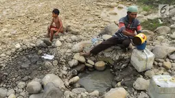 Warga mengambil air pada lubang di aliran Sungai Cipamingkis yang kering, Cibarusah, Bekasi, Jabar, Kamis (2/8). Dua bulan tak diguyur hujan menyebabkan warga perbatasan Bogor-Bekasi dilanda kekeringan dan kesulitan air bersih. (Merdeka.com/Arie Basuki)