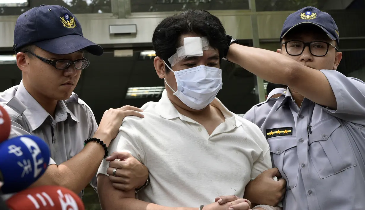Seorang pria saat dibekuk aparat kepolisian di Taipei, Taiwan, Jumat (18/8). Pria yang diidentifikasi bernama Lu tersebut berusaha masuk Istana Kepresidenan Taiwan dengan membawa pedang Samurai. (AFP Photo/Sam Yeh)