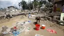 Seisi kota nyaris mati. Tidak ada listrik, air bersih, apalagi jaringan telekomunikasi. Warga seperti terperangkap. Tampak dalam foto, seorang korban selamat membersihkan diri di area yang terdampak banjir bandang di Aceh Tamiang, Sumatra, Jumat 5 Desember 2025. (AP Photo/Binsar Bakkara)