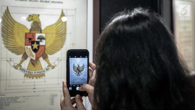 Pengunjung mengabadikan lambang Garuda di Museum Nasional, Jakarta, Jumat (2/6). Pameran digelar dari 2 hingga 15 Juni 2017, sebagai rangkaian kegiatan hari kelahiran Pancasila yang jatuh tanggal 1 Juni. (Liputan6.com/Faizal Fanani)