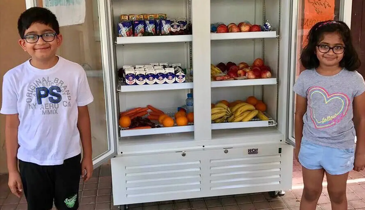 Dua orang anak berpose di depan kulkas yang berisi makanan dan minuman jelang bulan Ramadan di Dubai. Di Dubai setiap bulan Ramadan warga dan donatur mengisi kulkas yang berisi makanan dan minuman untuk berbuka puasa. (www.instagram.com/ramadanfridgesdxb)