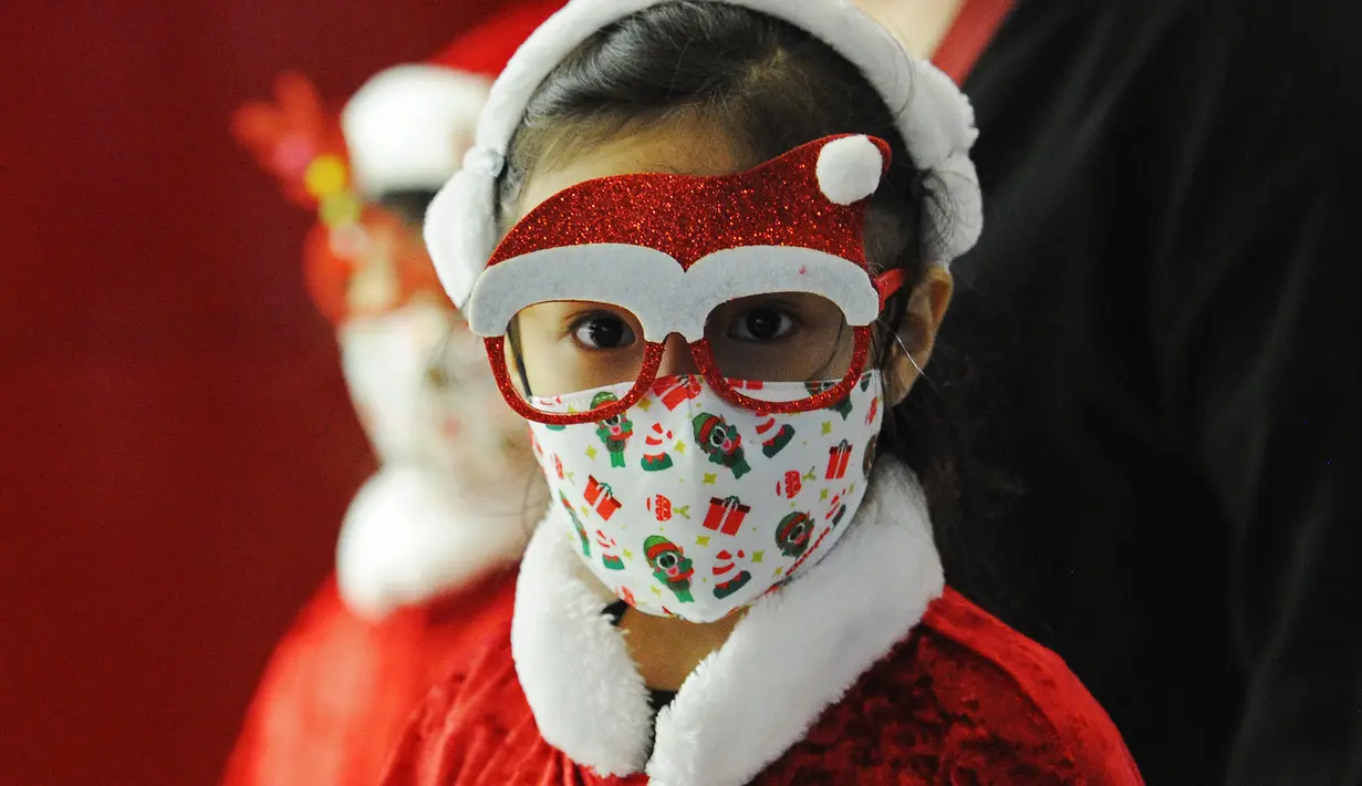 Seorang gadis kecil menikmati pemandangan dekorasi lampu Natal di sepanjang pusat perbelanjaan Orchard Road di Singapura (16/12/2020). Mengusung tema Love This Christmas, acara tahun ini lebih sunyi dari sebelumnya dikarenakan adanya pembatasan akibat pandemi COVID-19. (Xinhua/Then Chih Wey)