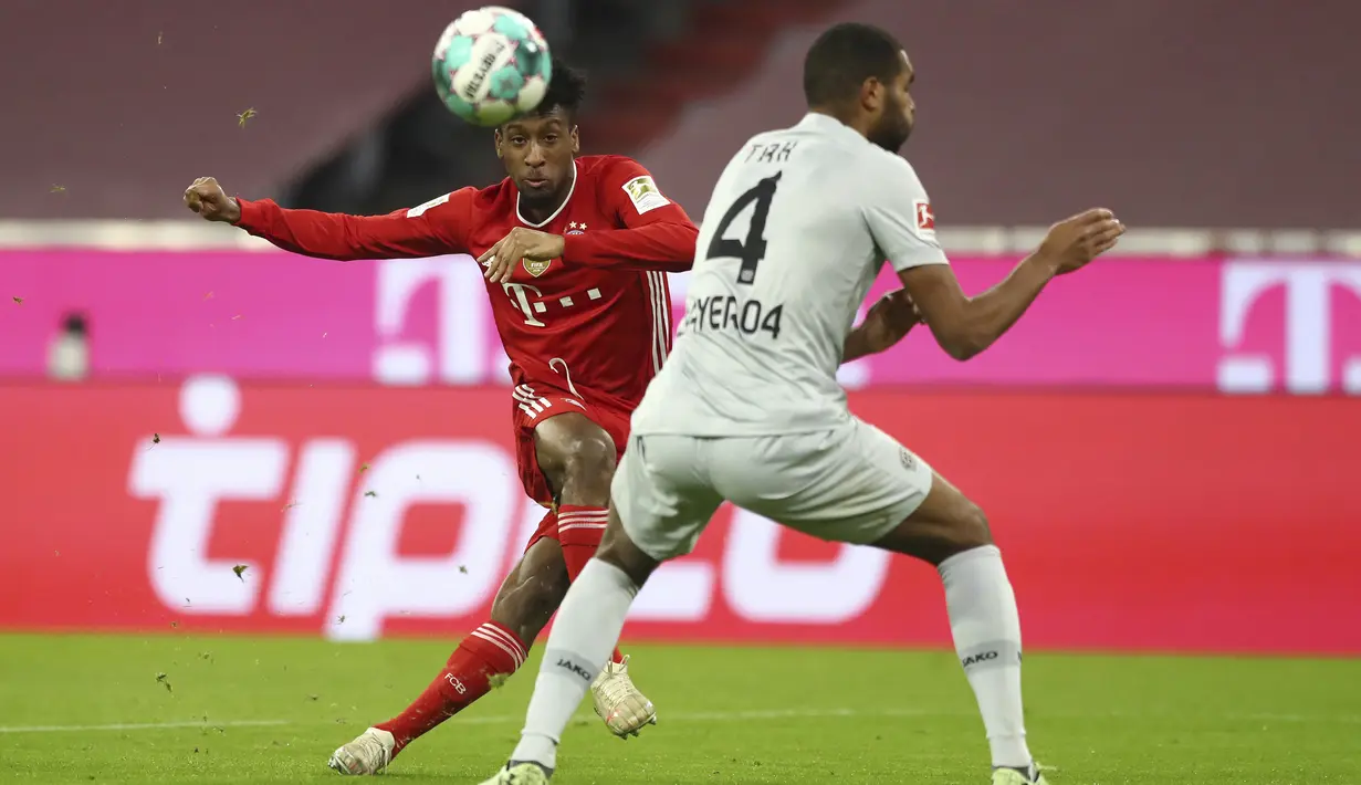 Pemain Bayern Munchen Kingsley Coman (kiri) menendang bola di depan pemain Bayer Leverkusen Jonathan Tah pada pertandingan Bundesliga di Stadion Allianz Arena, Munchen, Jerman, Selasa (20/4/2021). Bayern Munchen menang 2-0. (AP Photo/Matthias Schrader, Pool)